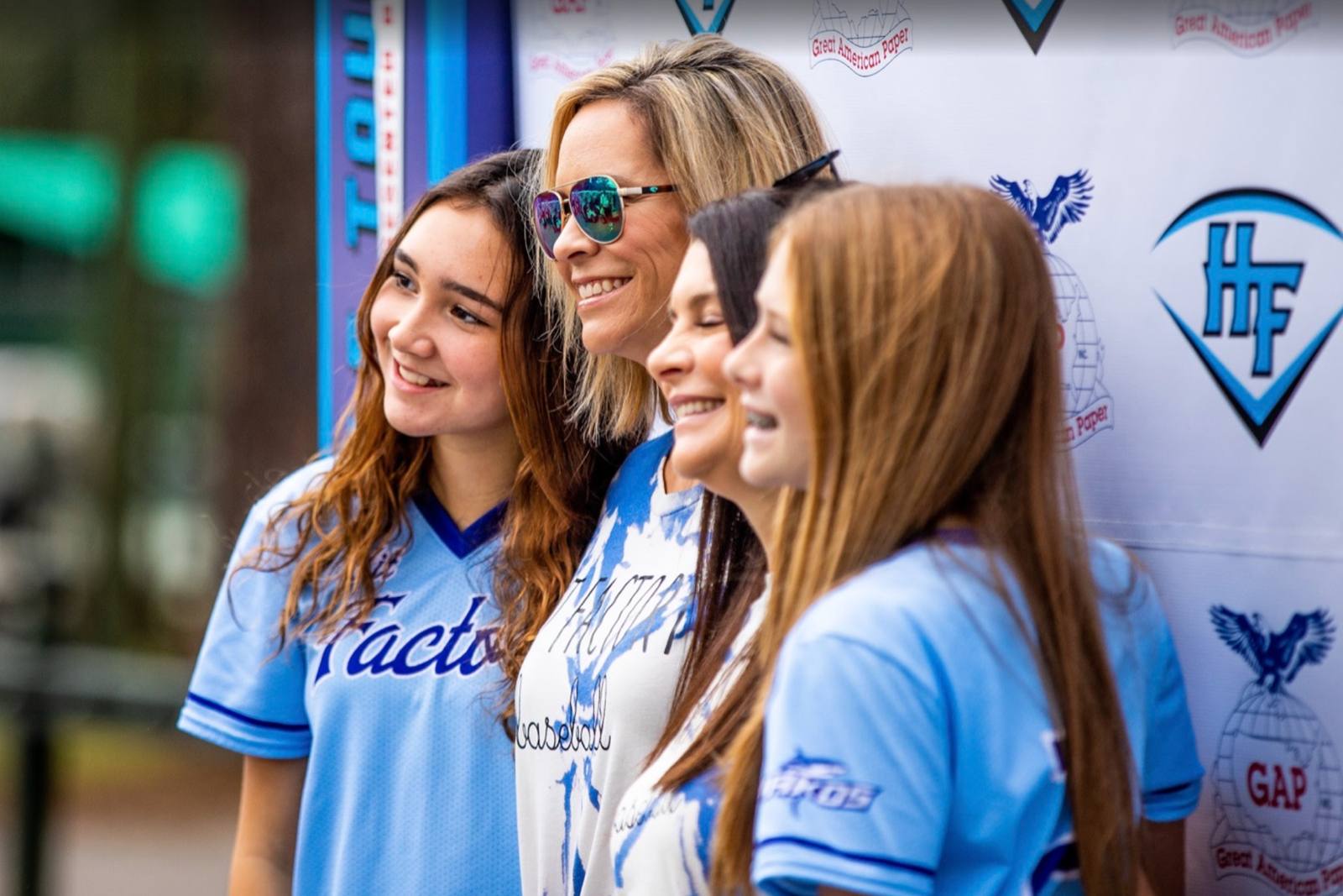 Players and a coach at a tournament photo backdrop